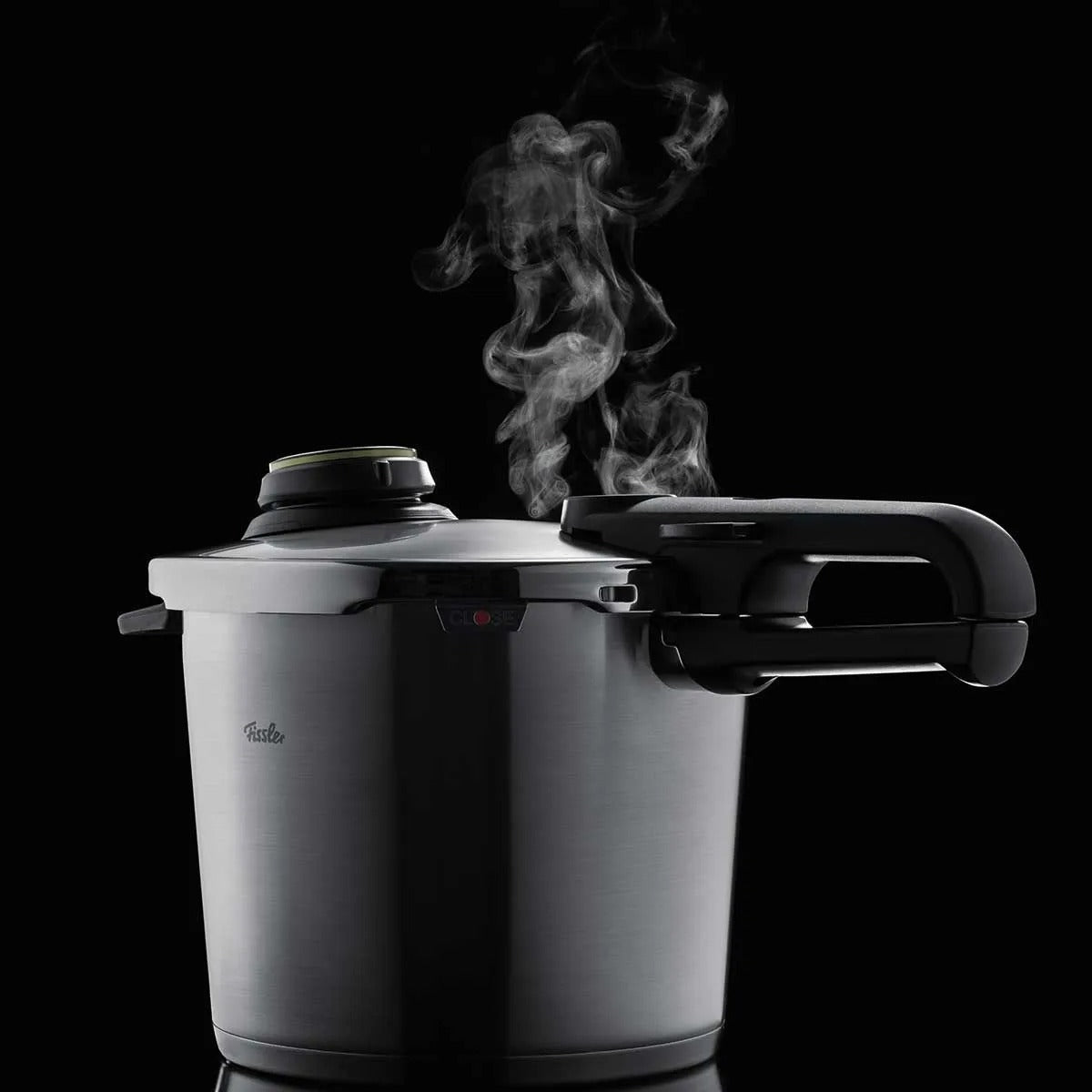 Pressure cooker with steam rising against a black background