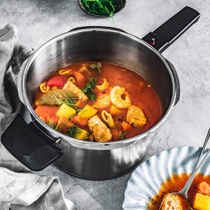 Stir-fry dish with vegetables and seafood in a metal pot on a gray surface.