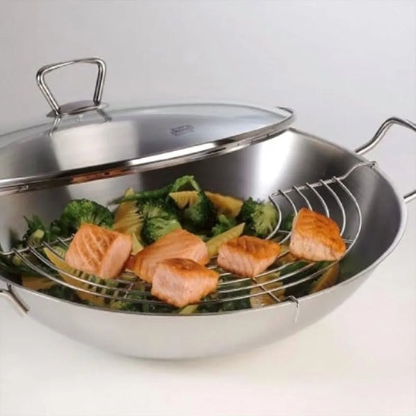 Stainless steel wok with salmon and vegetables on a white background